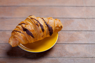 photo of delicious fresh croissant on the wonderful brown wooden background
