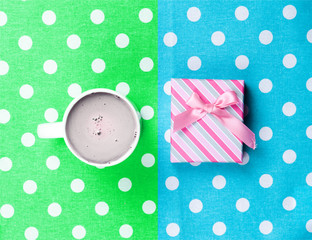 photo of cup of coffee and cute gift on the wonderful colorful dotted background in pop art style