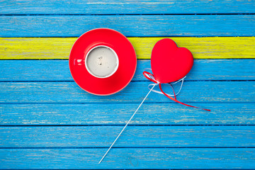 photo of cup of coffee and heart shaped toy on the wonderful wooden background in pop art style