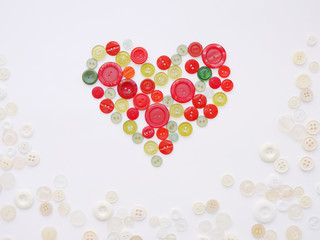Colorful heart made of buttons. Background of multi-colored buttons. Abstract background. Pattern of buttons on a white background.