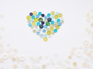 Colorful heart made of buttons. Background of multi-colored buttons. Abstract background. Pattern of buttons on a white background.