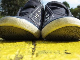 Blaue Schuhe auf gelber Bank