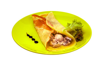Green pancakes with filling and salad on a green plate isolated on white background