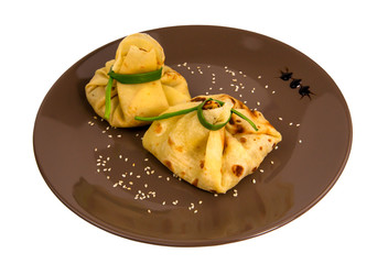 Green pancakes with filling on a plate isolated on white background