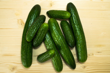 Green cucumbers on wooden table, top view