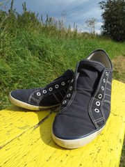 Blaue Schuhe auf gelber Bank