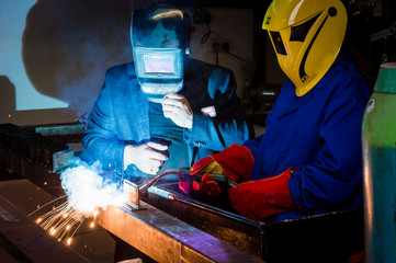 Workers weldings in a factory with sparks