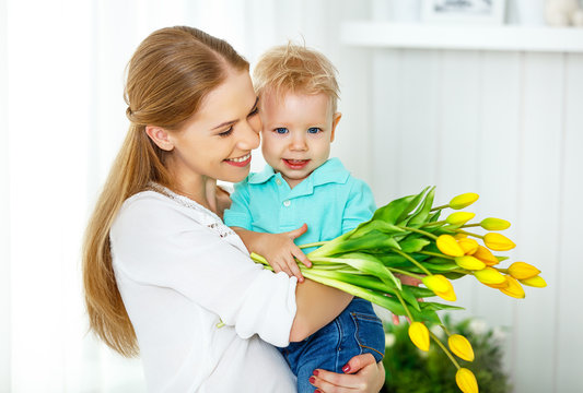 Happy mother's day. Baby son gives flowers for mom