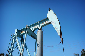 old risted oil derrick with blue sky