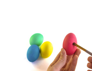 Hand painting easter egg with paintbrush on a white background