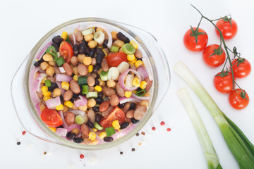 Healthy mixed beans and vegetables salad bowl. Top view. White background.