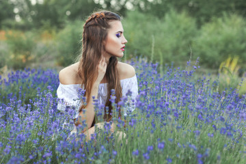 Portrait of a woman among blue lavender flowers.