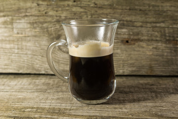 Cup and grain of coffee over wooden background
