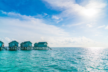 Beautiful water villas in tropical Maldives island at the sunset time .
