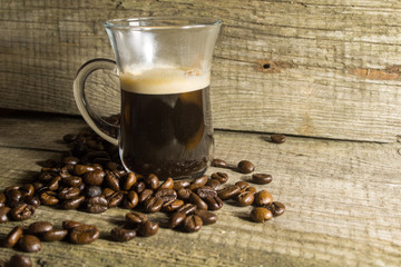 Cup and grain of coffee over wooden background