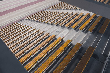 wide angle view of rows of wooden yellow stadium seats seen from above