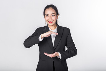 Beautiful Asian businesswoman show something between her hands. Copyspace for your text or product.