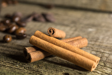 Cinnamon sticks with coffee grains on wooden background