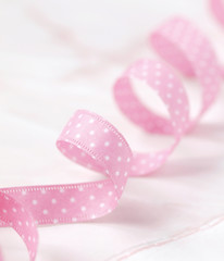 Pink dotted ribbon on light marble background
