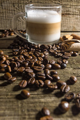 Cup of cappuccino and grain of coffee over wooden background