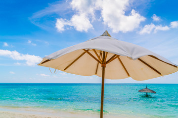 Obraz na płótnie Canvas Beach chairs with umbrella at Maldives island, white sandy beach and sea .