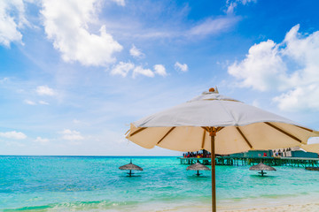 Beach chairs with umbrella at Maldives island, white sandy beach and sea .
