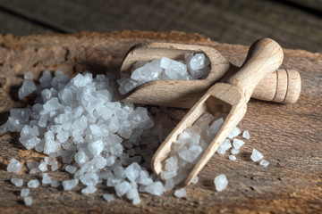 Cyprus sea salt flakes over bark on wooden background