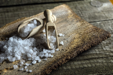 Cyprus sea salt flakes over bark on wooden background
