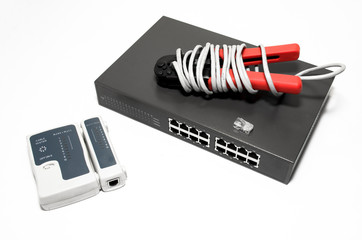 Naklejka premium Network switch, ethernet cable, crimper and RJ45 cable tester isolated on white. Network tools technology background.