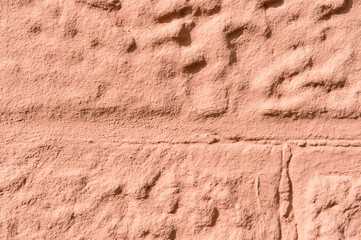 sandstone wall with vertical and horizontal lines, red background