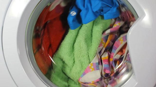 clip of a high efficiency washing machine (side loader) washing laundry starting up after being closed