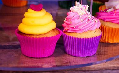 Two colourful cupcakes .