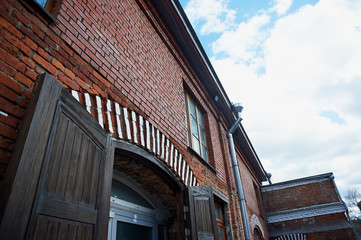 Obraz premium Old brown wooden door red brick masonry. The old Soviet factory.