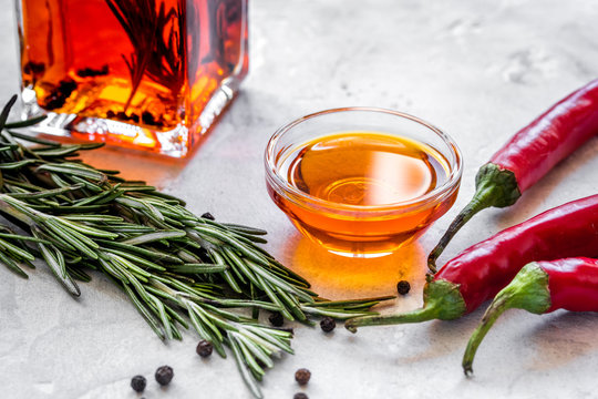 jar with oil and chili on stone table background