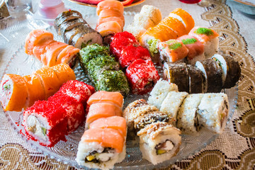Big roll sushi set on a large plate at home.