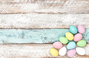 Pastel colored easter eggs wooden background