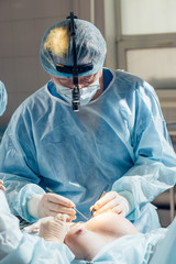 Stitching the patient's skin, the self-extracting threads, after surgery. breast augmentation,...