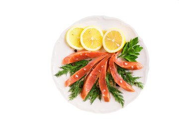 salted salmon fillet slices with lemon and herbs on a plate