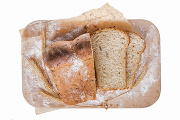freshly baked bread on wooden cutting board with wheat ears