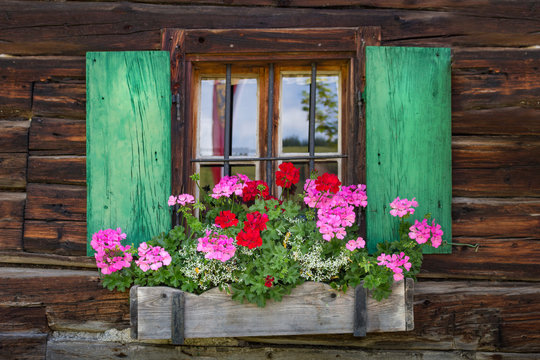 Fototapeta Window of a wooden mountain hut in the alps