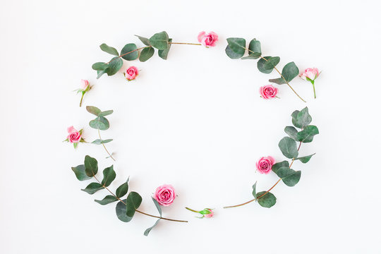 Flowers composition. Frame with rose flowers and eucalyptus branches. Flat lay, top view