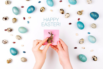 Happy Easter card. A woman is holding a rabbit against the background of Easter eggs. Copy space for your text