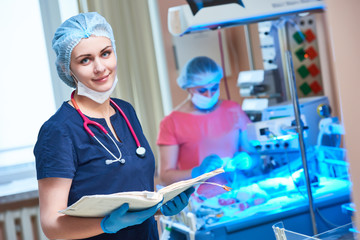 Female doctor portrait in front of intensive care unit for newborn infant baby