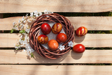 Easter eggs in nest on rustic wooden planks