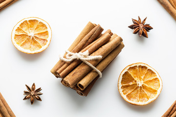 Cinnamon sticks with star anise and orange slices on white background