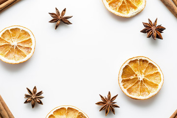 Cinnamon sticks with star anise and orange slices on white background