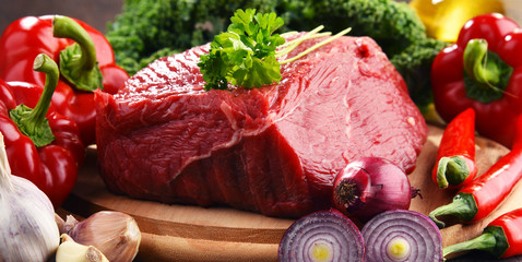 Piece of beef and spices on cutting board