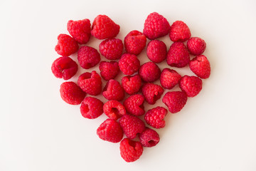 Juicy red heart made of organic fresh raspberries on white background. Healthy food for healthy life. Valentine's day
