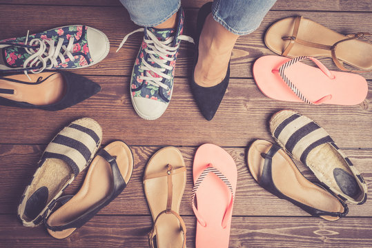 Collection of female shoes on wooden floor. Fashion background