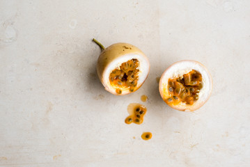 High angle view of panama gold passionfruit in halves on cream limestone background with copy space to left